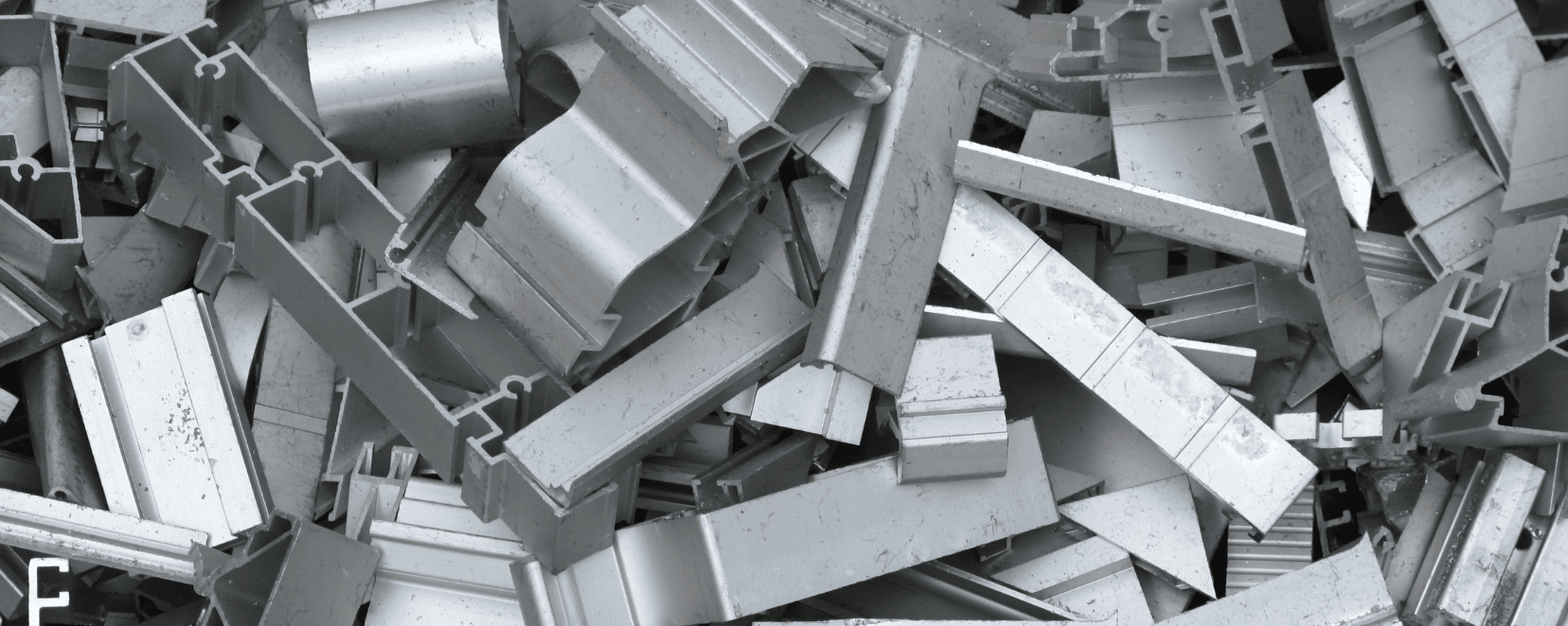 Eine Nahaufnahme zeigt viele identische Metallteile aus dem 3D Metalldruck, die dicht aneinander auf einer Fläche liegen