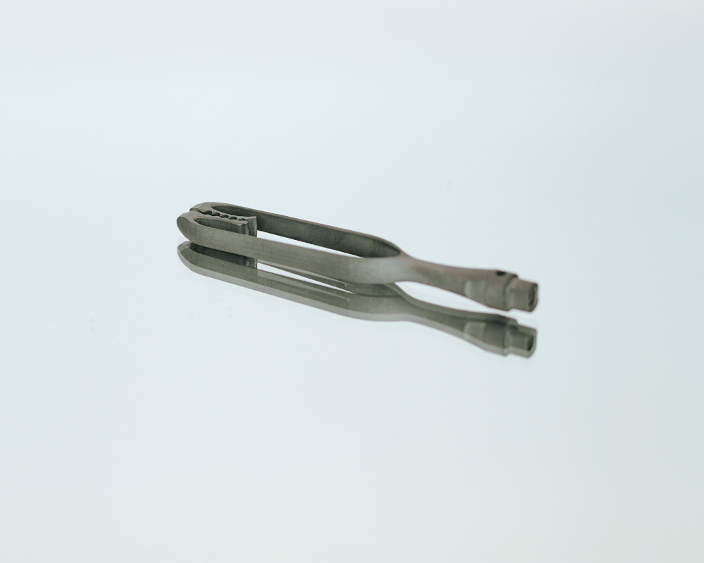 Ein medizinisches Werkzeug aus Titan steht auf einem Spiegel und wurde im Metall 3D Druck Service von Laser Add Concept gefertigt