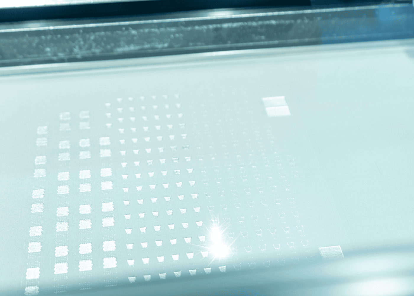 Eine Laserschmelzmaschine bei Laser Add Concept schmilzt mit ihrem Laser eine dünne Schicht Metallpulver im SLM Verfahren auf