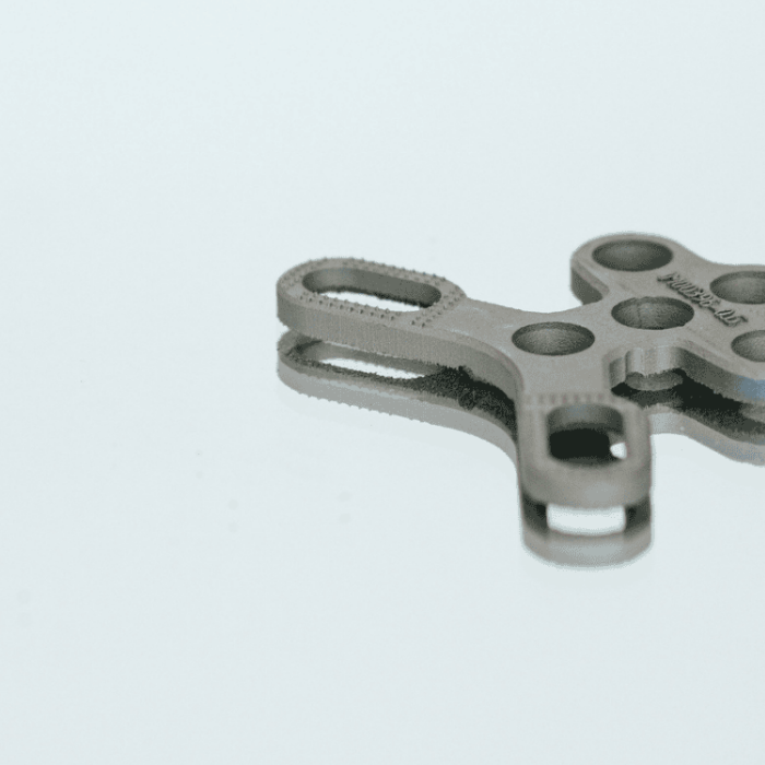 Ein 3D Druck Medizin Produkt in Form eines Knochenbauteils für das Handgelenk liegt auf einem neutralen Hintergrund platziert